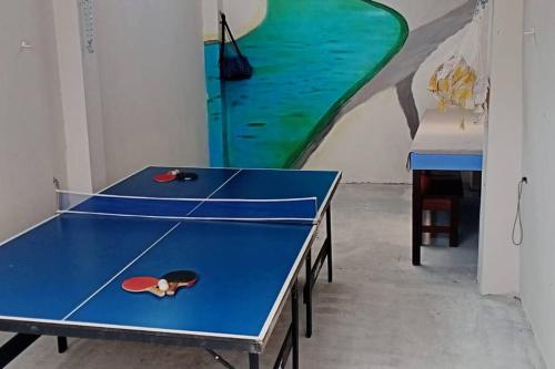 two ping pong tables in a room with a mural at Residência Ilha Bela in São Luís