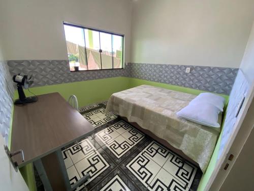 a room with a bed and a table and a window at Apartamento Centro in Ametista do Sul