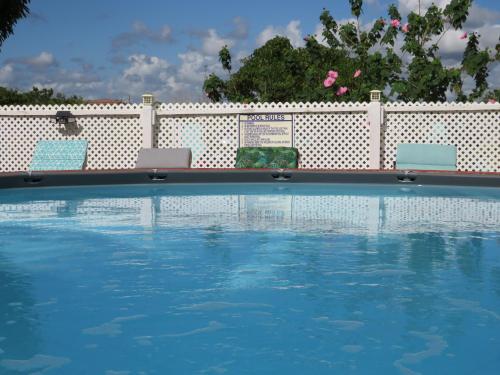 two chairs and a swimming pool in front of a fence at LAKE VIEW CONDO in Belize City