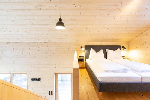a bedroom with a large bed in a wooden wall at Masura Cabins in Bürserberg