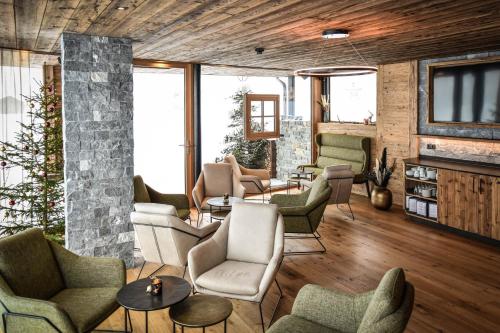a living room with couches and chairs and a fireplace at alpdeluxe-Apartments Holzgau in Holzgau