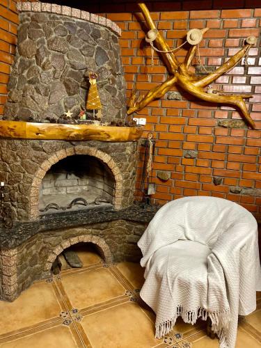 a brick fireplace with a chair in front of it at SoloMia in Mykulychyn