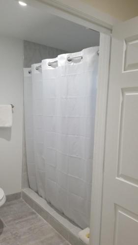 a bathroom with a toilet and a glass shower door at Royale Inn Motel in Whittier