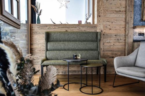 a living room with a chair and two tables at NATURPARKGUT - alpdeluxe Apartments in Holzgau
