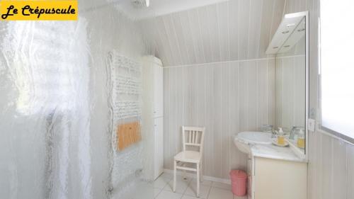 une salle de bain blanche avec un lavabo et des toilettes dans l'établissement Le Crépuscule, 300m de la plage, animaux de compagnie bienvenue, à Gouville-sur-Mer
