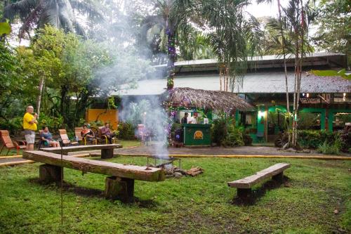 a fire pit in a park with people sitting around it at La Palapa Hut Nature Hostel in Puerto Jiménez