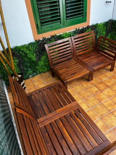 twee houten banken op een patio bij Cozy apartment in centric area at caleta de fuste with Air Conditioner in Caleta De Fuste