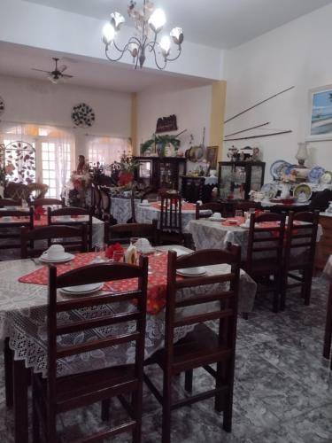 a dining room with tables and chairs and a chandelier at Pousada Oca Porã in Conservatória