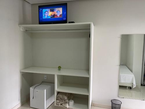 a tv sitting on top of a shelf in a room at Pousada Xero in Capitólio