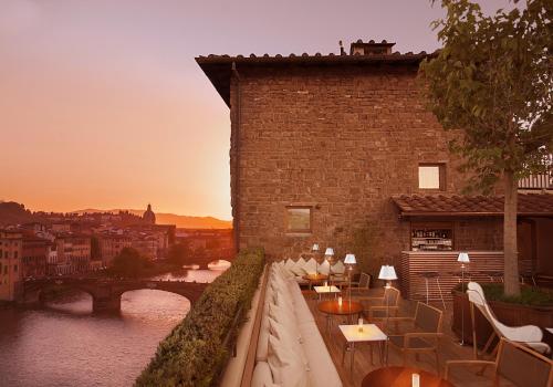 フィレンツェにあるHotel Continentale - Lungarno Collectionのテーブルと椅子が備わる建物の景色を望めます。