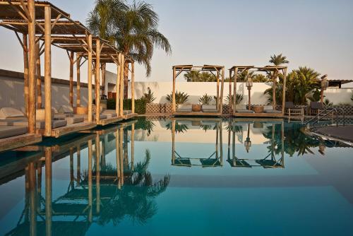 a swimming pool with blue water and palm trees at Casa Cabana Boutique Hotel & Spa - Adults Only in Faliraki