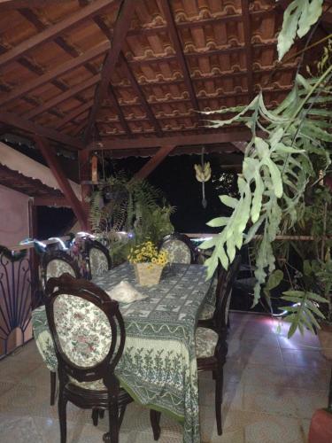 a dining room table with chairs and a green tablecloth at Pousada Oca Porã in Conservatória