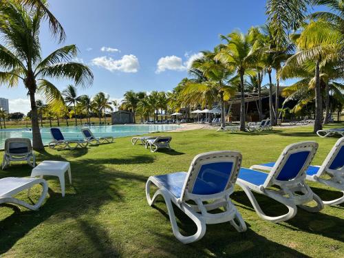 a group of chaise lounges and chairs next to a pool at BlueLagoon Apartamento en Playa Blanča in Playa Blanca