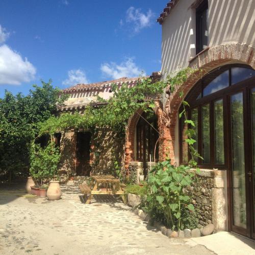 a brick building with ivy on the side of it at Il Portico Guesthouse in Muravera