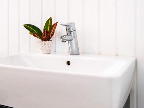 a white sink with a faucet and a plant on it at 4 person holiday home in Hejls in Hejls