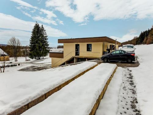 a car parked in front of a house in the snow at Beautiful cottage in La Chaux with jacuzzi in La Chaux