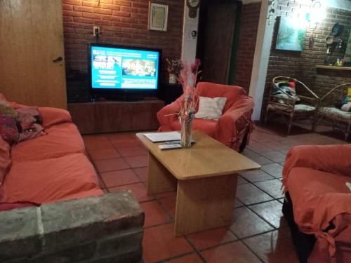 a living room with two couches and a table with a tv at Casa de montaña, valle del sol, potrerillos, Mendoza in Mendoza