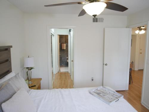 a bedroom with a white bed and a ceiling fan at Cozy Condo near Buckhead in Atlanta
