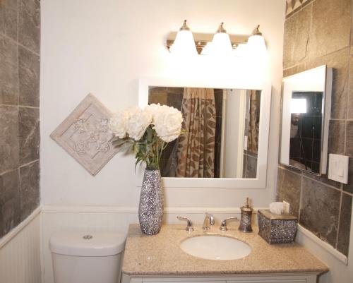 a bathroom with a sink and a vase with white flowers at Cozy Condo near Buckhead in Atlanta