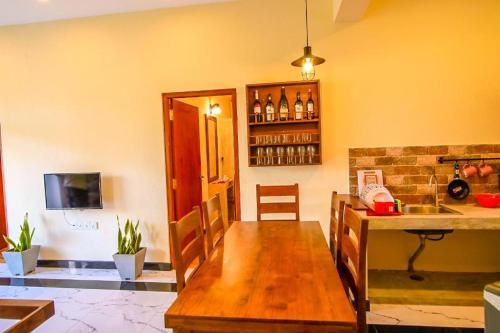 a dining room with a wooden table in a kitchen at Athithi Villa in Hikkaduwa
