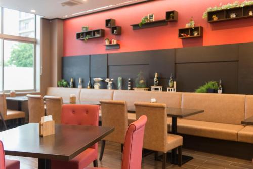 a restaurant with tables and chairs and a bar at Hotel Lifetree Hitachinoushiku in Ushiku