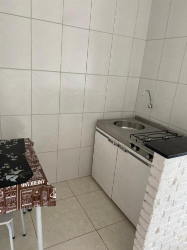 una piccola cucina con lavandino e piano cottura di Flat a 500 metros do centro a São Lourenço