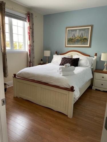 um quarto com uma grande cama branca e piso em madeira em Dida em Saint-Sauveur-des-Monts