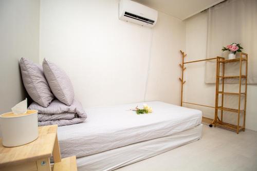 a small room with a bed with white sheets at YAB-GuestHouse, FemaleOnly, ForeignOnly in Seoul
