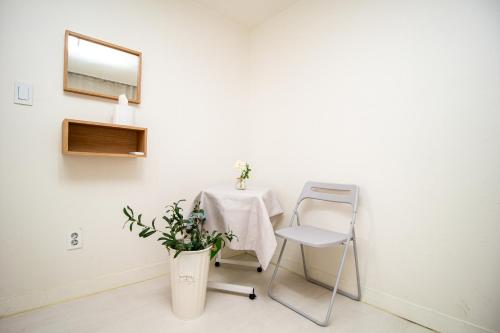 a white room with a table and a chair at YAB-GuestHouse, FemaleOnly, ForeignOnly in Seoul