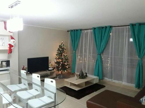 Sala de estar con árbol de Navidad y TV en Laguna Bahía Fernanda en Algarrobo