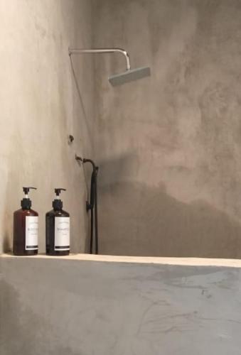 two bottles ofodorizers sitting on a shelf in a bathroom at Sawah Ijen in Licin