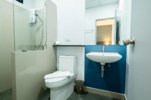 a bathroom with a white toilet and a sink at Kuda Asia Hotel Bang Saen in Bangsaen