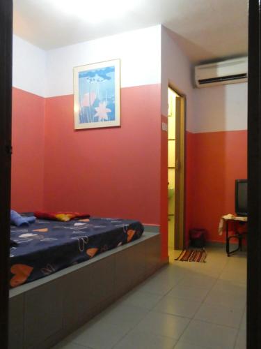 a room with a bed and a wall with a picture at TIT MOTEL in Sungai Petani