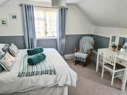 een slaapkamer met een bed, een bureau en een stoel bij The Coach House in Newport