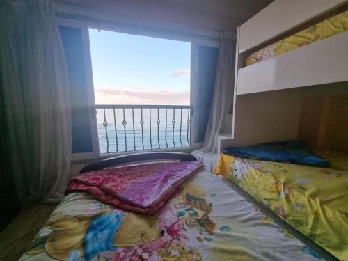 Panoramic Sea View ZAMZM Flat miami FAMILY ONLY شقة فندقية زمزم بانورما بشاطئ ميامي - الاسكندرية صف اول مباشر علي بحر - عائلات فقط في الإسكندرية: غرفة نوم بها سرير ونافذة ذات إطلالة
