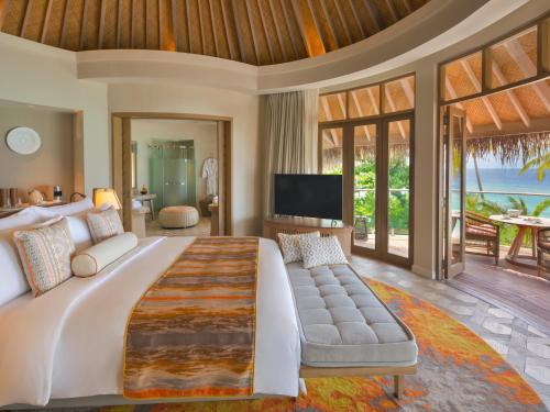a bedroom with a large bed and a television at The Nautilus Maldives in Baa Atoll