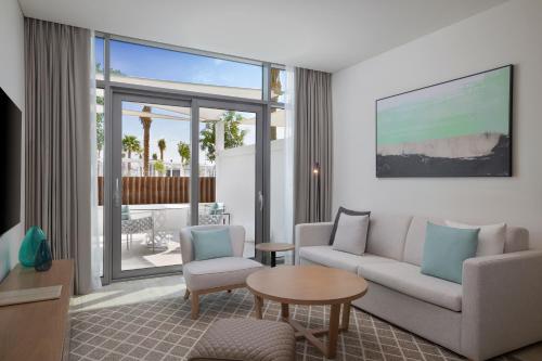 a living room filled with furniture and a large window at Doubletree By Hilton Abu Dhabi Yas Island Residences in Abu Dhabi