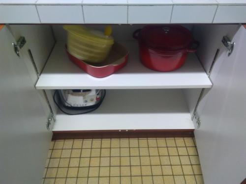 a cupboard with bowls and dishes on a shelf at Mlle Labeaume in Aigueperse
