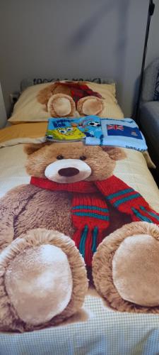 a large teddy bear laying on a bed at ANKER SILVER DREAM in Kaposvár