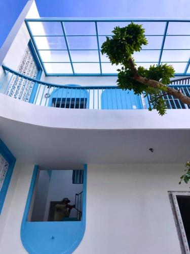 a person taking a picture in a window of a building at Cô Tư's Homestay in Phan Thiet