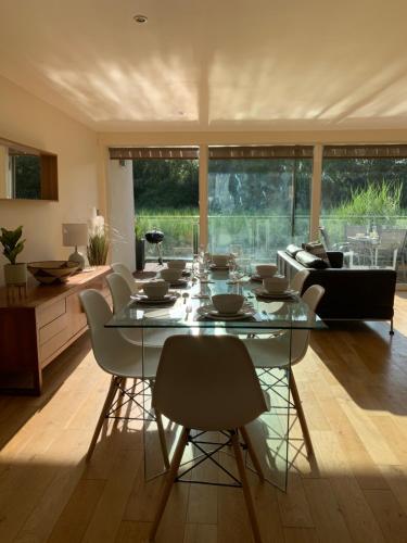 a dining room with a glass table and chairs at Harrier Lodge in Cirencester