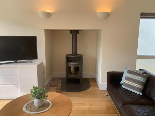 a living room with a wood stove in the corner at Harrier Lodge in Cirencester