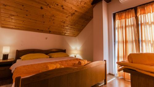 a bedroom with a bed and a large window at Guest House Rustico in Korenica