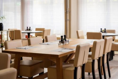 a conference room with a wooden table and chairs at Four Stars by City Hotel in Meckenheim