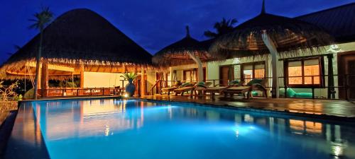 福拉杜島的住宿－Island Luxury Boutique Hotel - Fulhadhoo，夜间在房子前面的游泳池