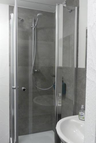 a shower with a glass door next to a sink at Eifel Bauernhaus Müllesch in Berenbach