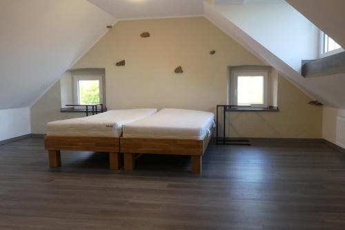 a large bedroom with a bed in a attic at Eifel Bauernhaus Müllesch in Berenbach