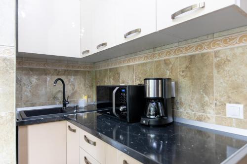 a kitchen with a microwave and a coffee maker on a counter at Sud Dreams Apartments in Bucharest