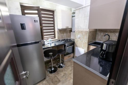 a kitchen with a refrigerator and a counter top at Sud Dreams Apartments in Bucharest