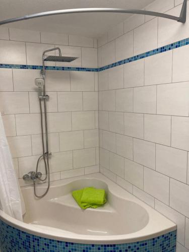 eine Badewanne mit einem grünen Handtuch. in der Unterkunft Ferienwohnung Am Schlosspark Ettersburg bei Weimar in Ettersburg